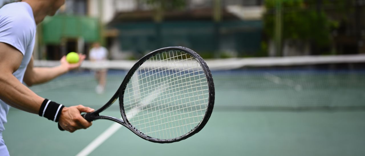 Person spielt Tennis auf einem Tennisplatz
