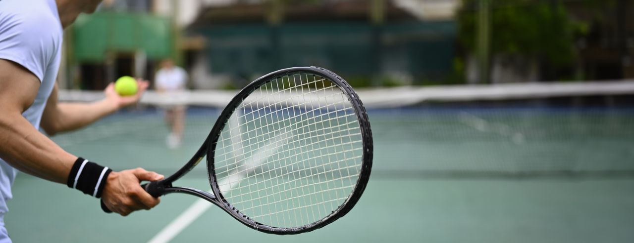 Person spielt Tennis auf einem Tennisplatz