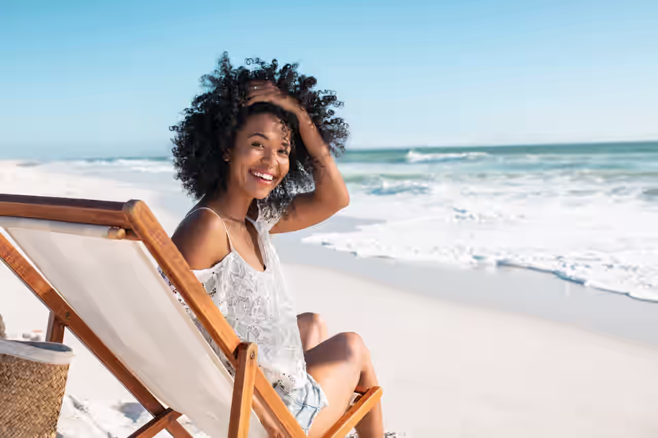 Eine Frau sitzt auf einem Stuhl am Strand