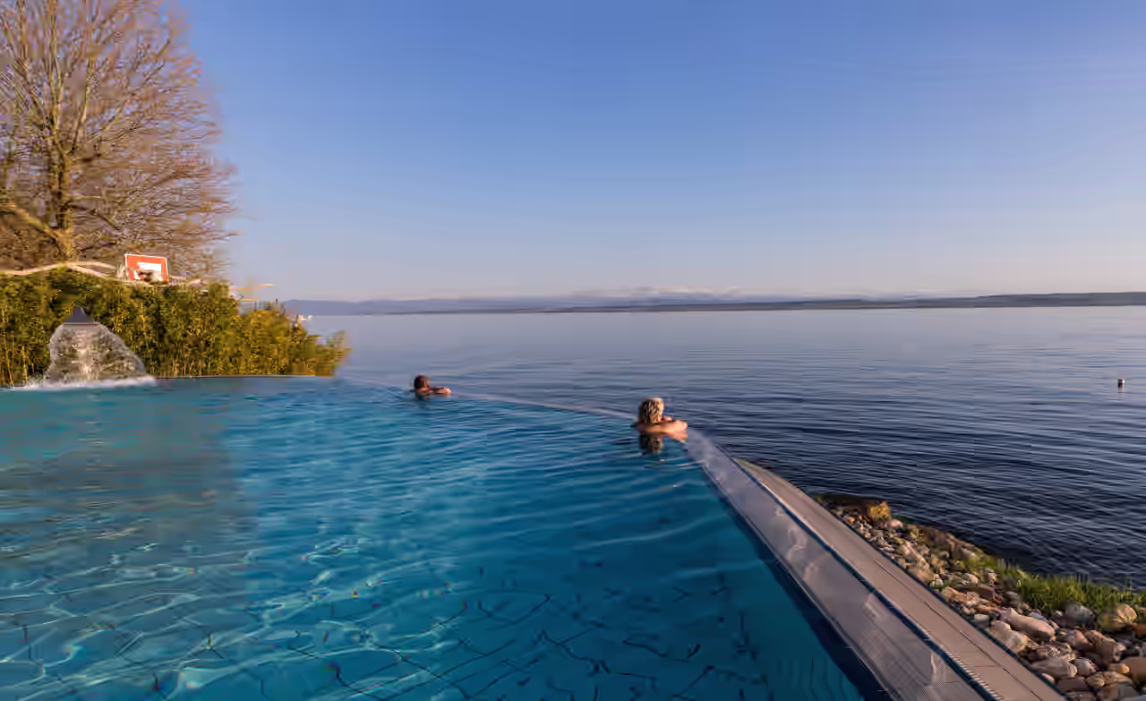 Zwei Personen im Infinity-Pool mit Blick auf den Bodensee