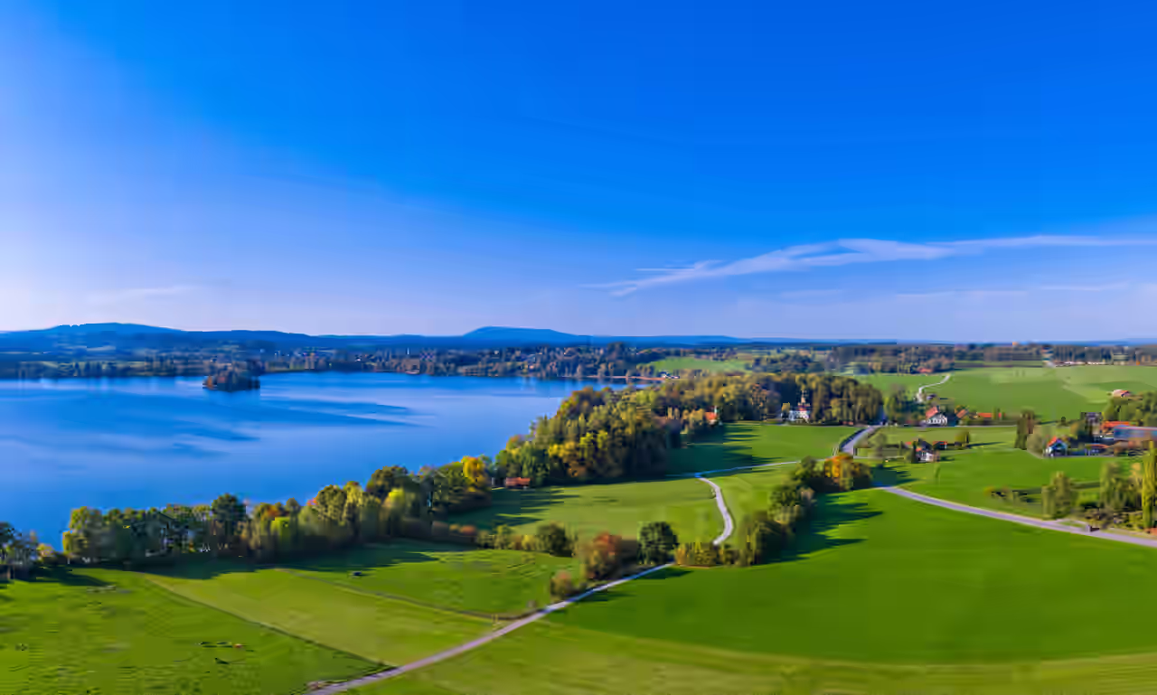Staffelsee in Bayern, Deutschland, umgeben von Bäumen und Wiesen im Sonnenschein