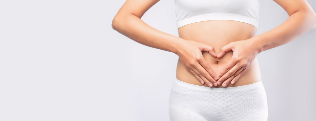 Eine Frau formt ein Herz vor ihrem Bauch