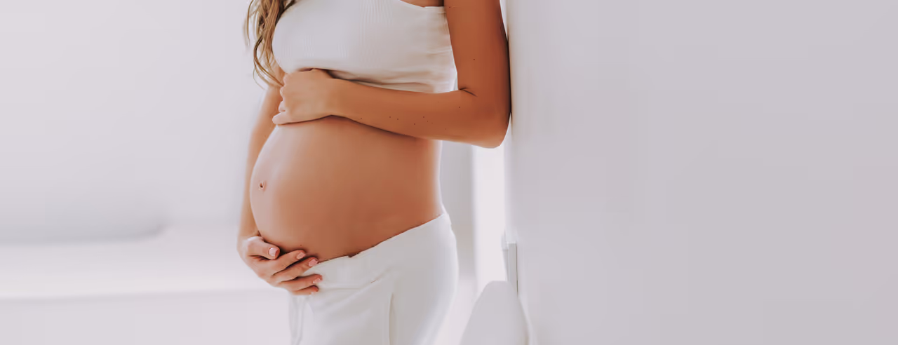 Eine Frau hält sich ihren Schwangerschaftsbauch