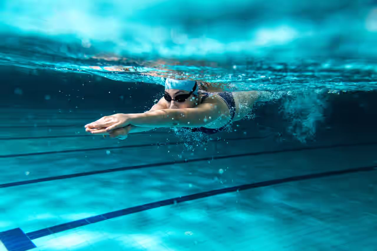 Frau, die in einem Sportbecken Bahnen schwimmt