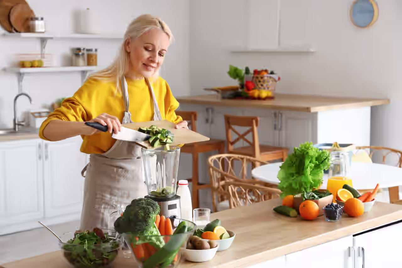 Frau verarbeitet Lebensmittel für eine Basenfasten Kur im Mixer
