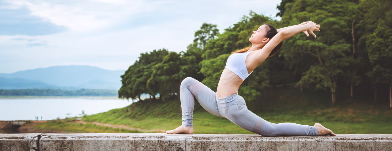 Eine Frau in Yoga Pose übt Yoga im freien gegen chronische Rückenschmerzen
