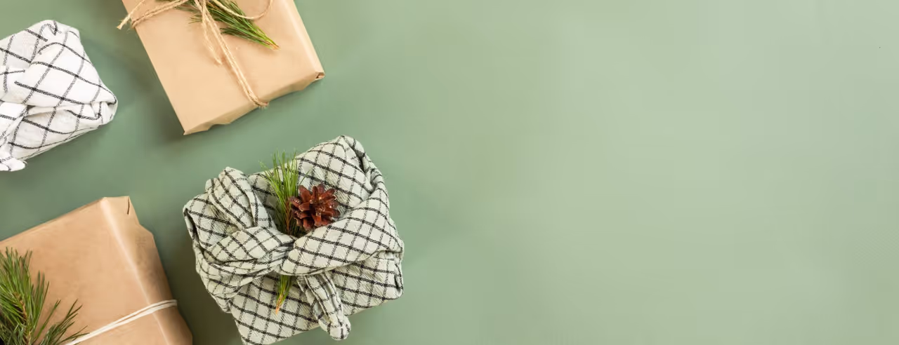 Geschenke vor einem grünen Hintergrund in nachhaltigem Papier oder Geschirrtuch verpackt