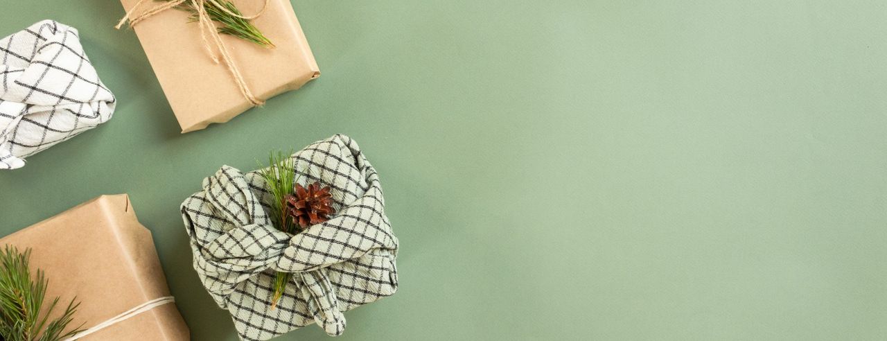 Geschenke vor einem grünen Hintergrund in nachhaltigem Papier oder Geschirrtuch verpackt