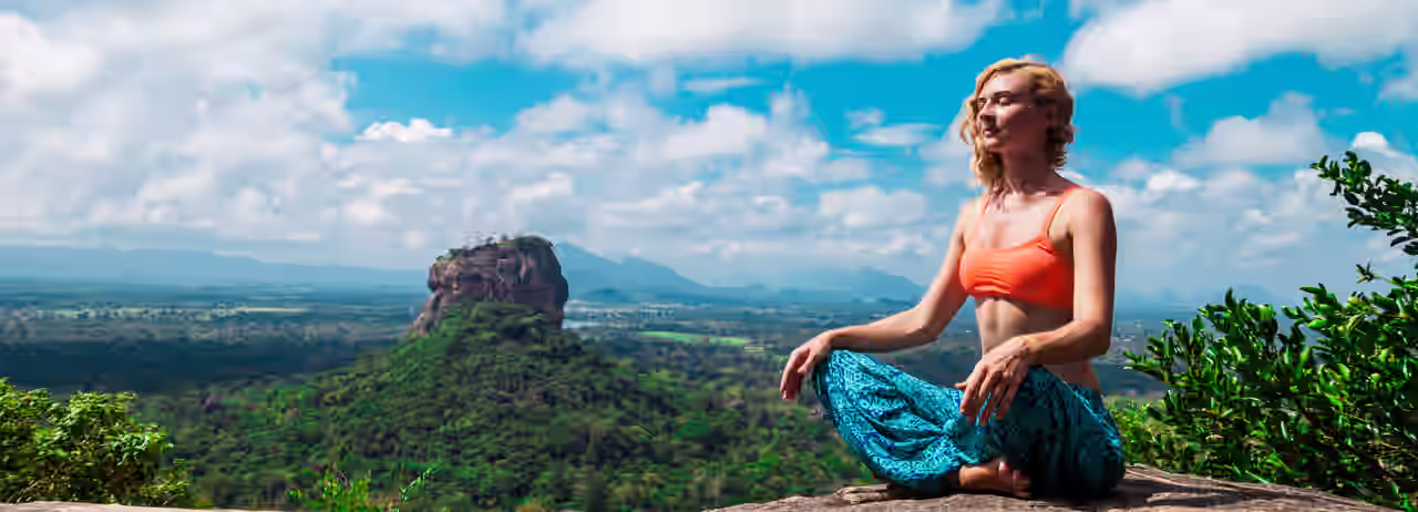 Eine Frau meditiert vor dem Löwenfelsen