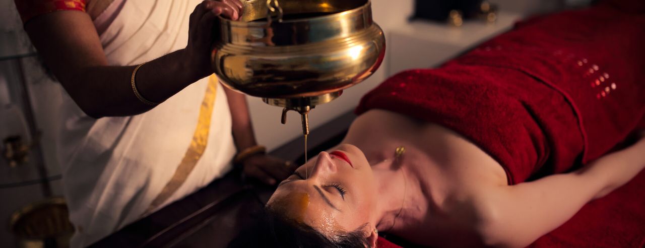 Eine Frau beim ayurvedischen Stirnölguss