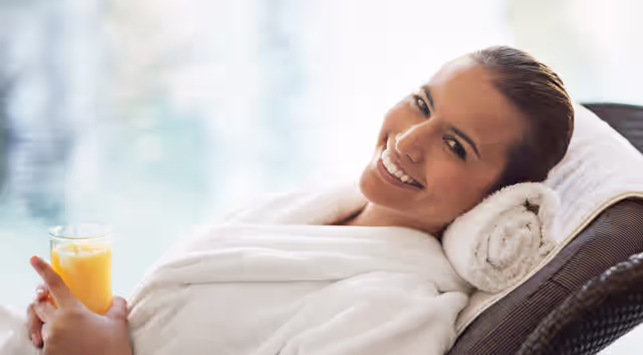 Eine ältere Frau mit Sonnenbrille und Bademantel