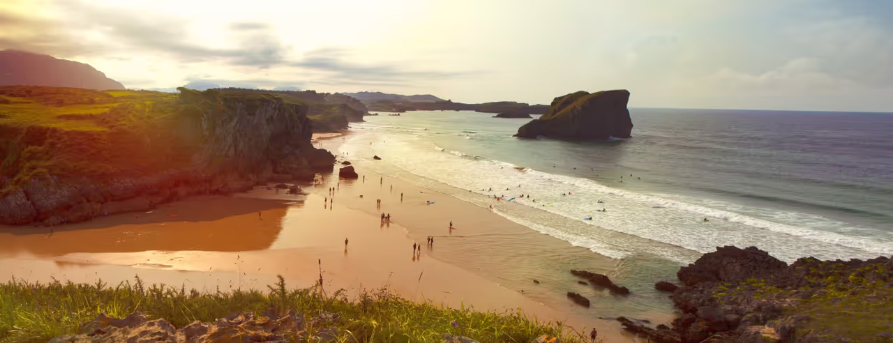Strand in Spanien mit vielen Menschen die Baden