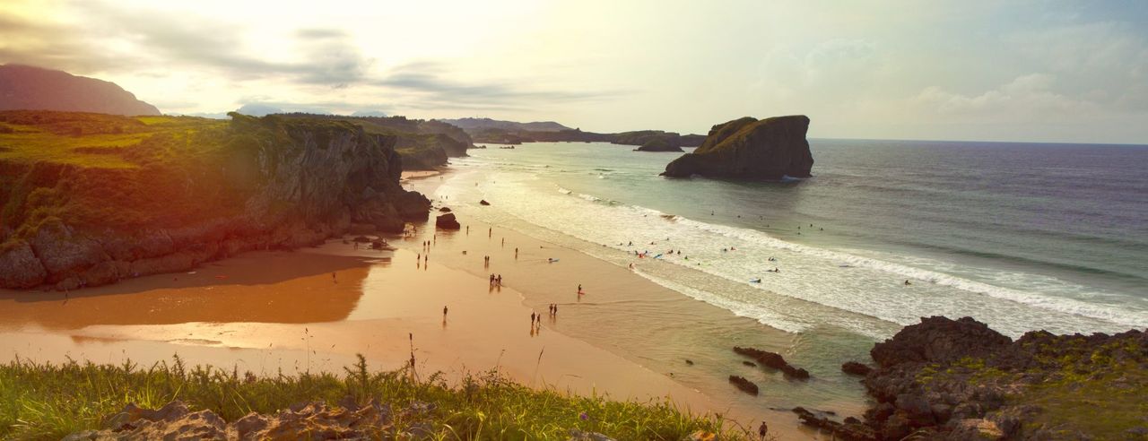 Strand in Spanien mit vielen Menschen die Baden