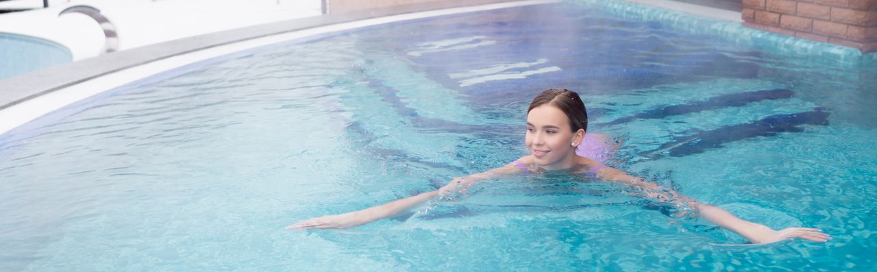 Eine Frau schwimmt im Thermalwasserpool