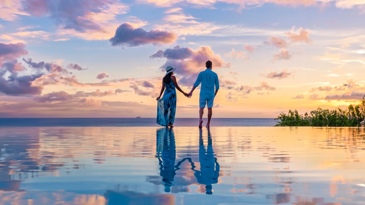 Ein Paar am Rande des Infinity Pools sin der Karibik