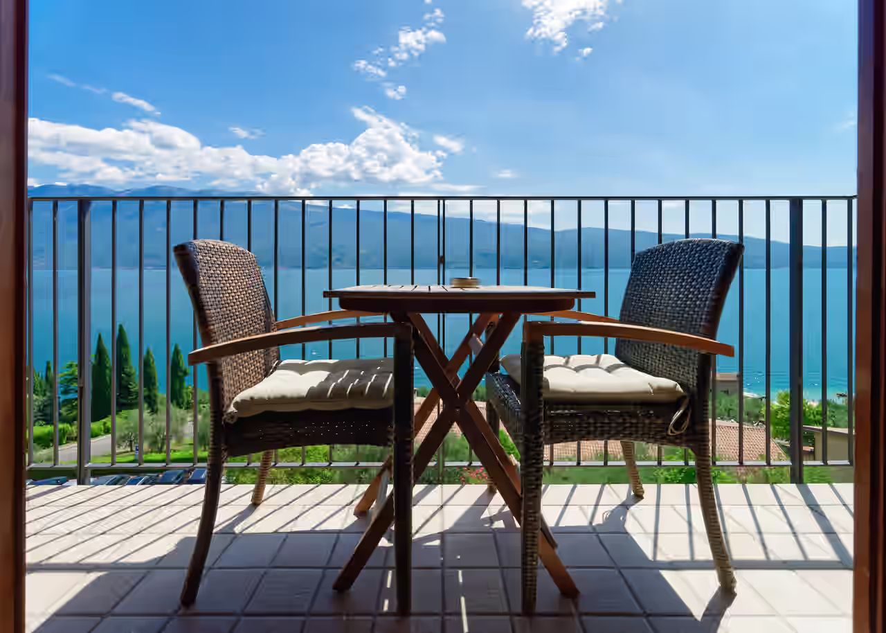 Balkon mit Tisch, Stühlen und Blick auf den Gardasee
