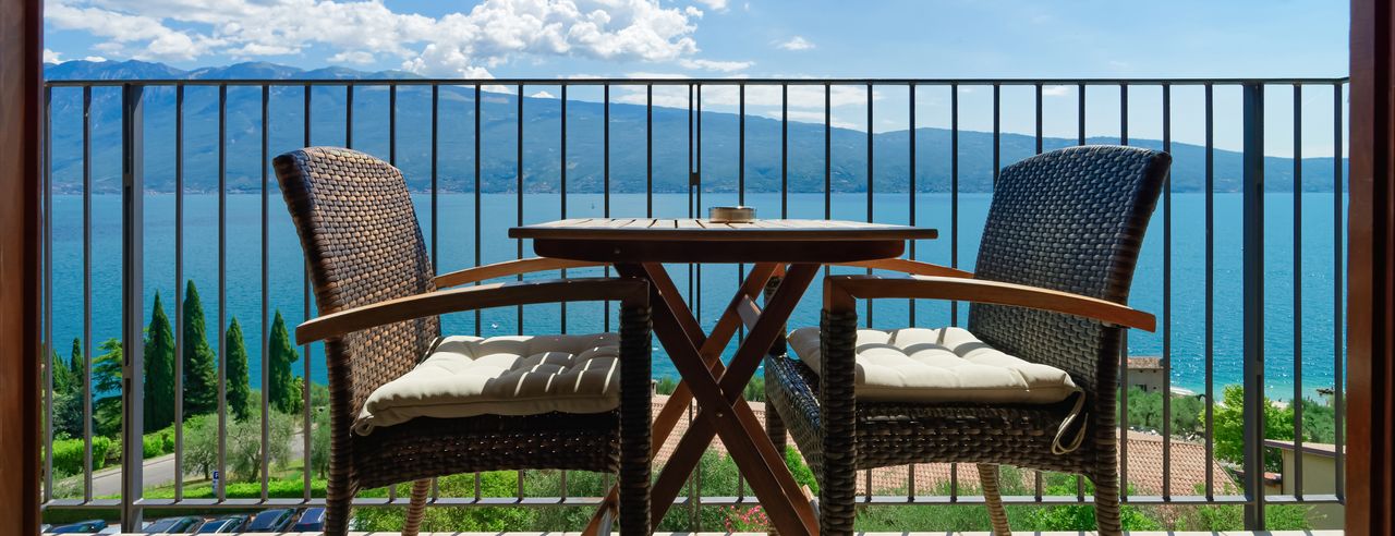 Balkon mit Tisch, Stühlen und Blick auf den Gardasee