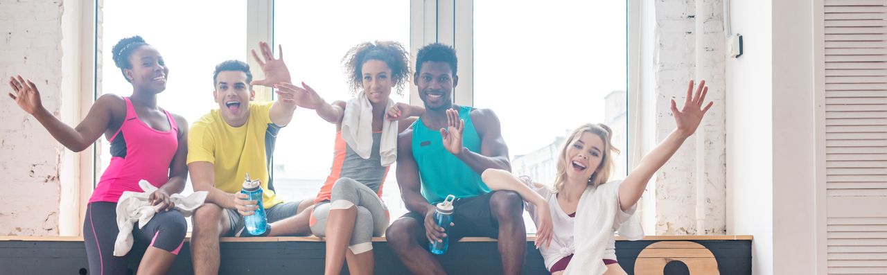 Eine Gruppe Sportler winkt zur Kamera