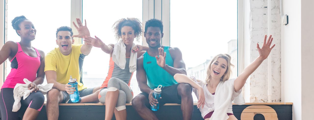 Eine Gruppe Sportler winkt zur Kamera