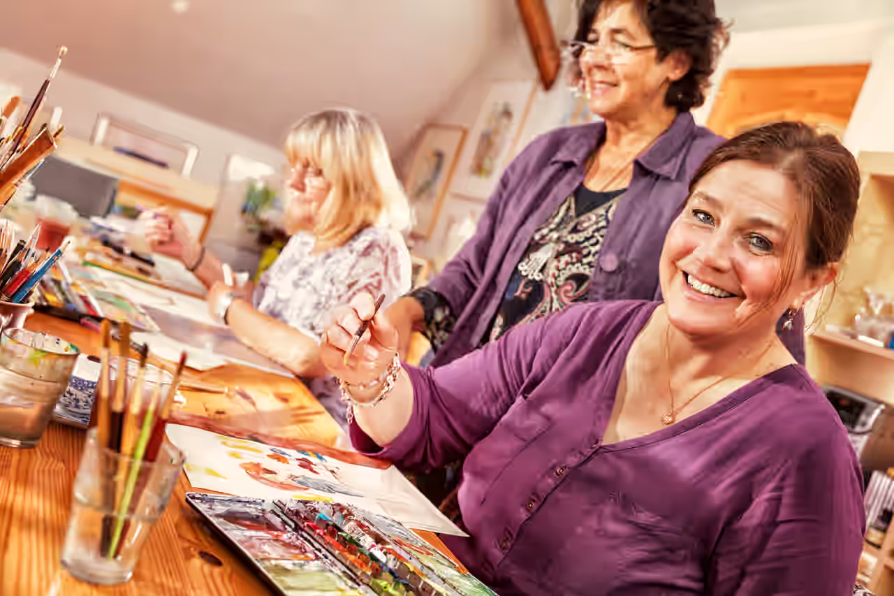 Frauen in einem Malkurs mit Leinwänden