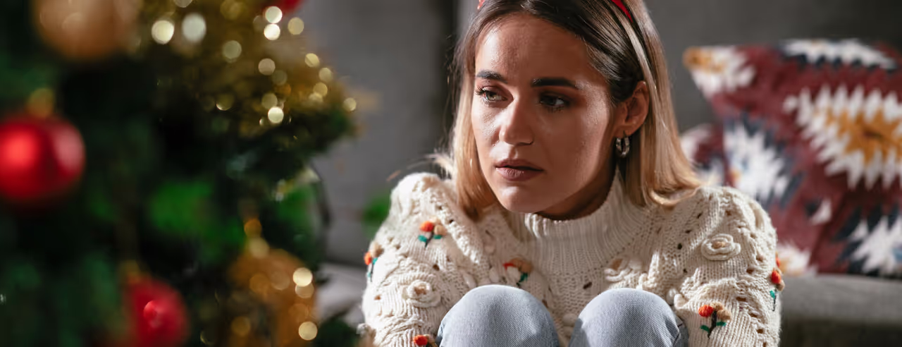 Frau traurig am Weihnachtsbaum