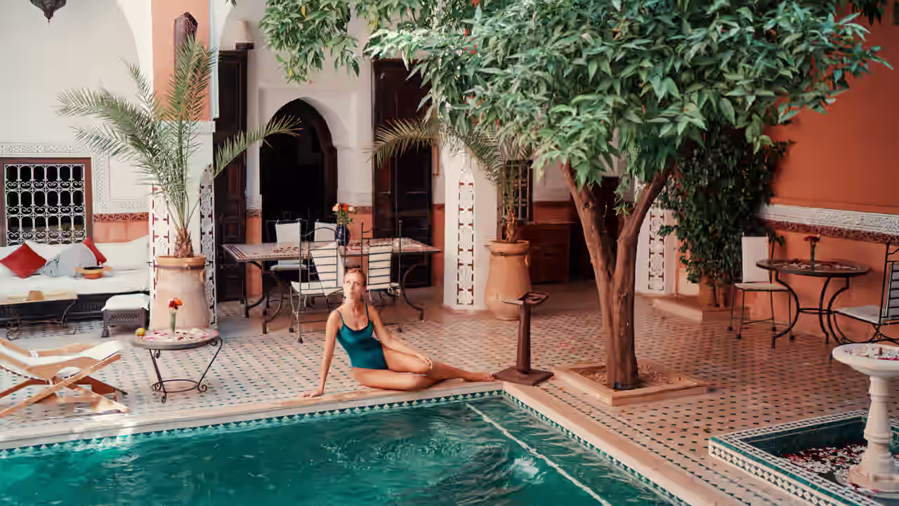 Eine Frau entspannt in einem Innenhof mit Pool
