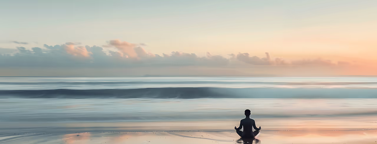 Une personne pratique le yoga devant la mer.