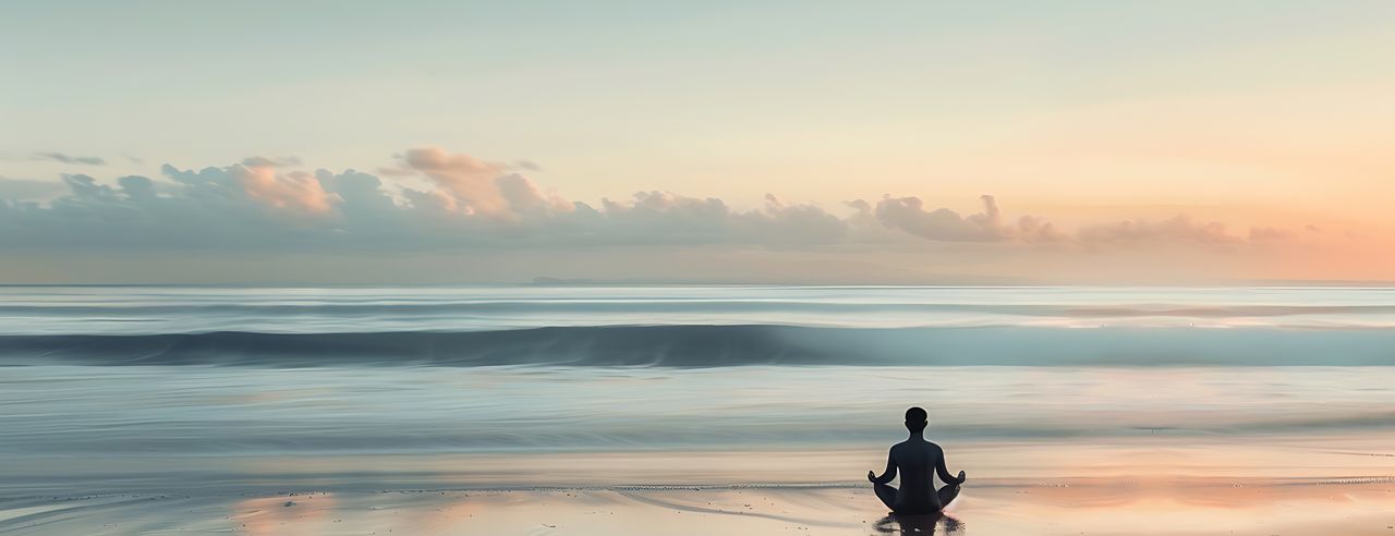 Ein Mensch praktiziert vor dem Meer Yoga.