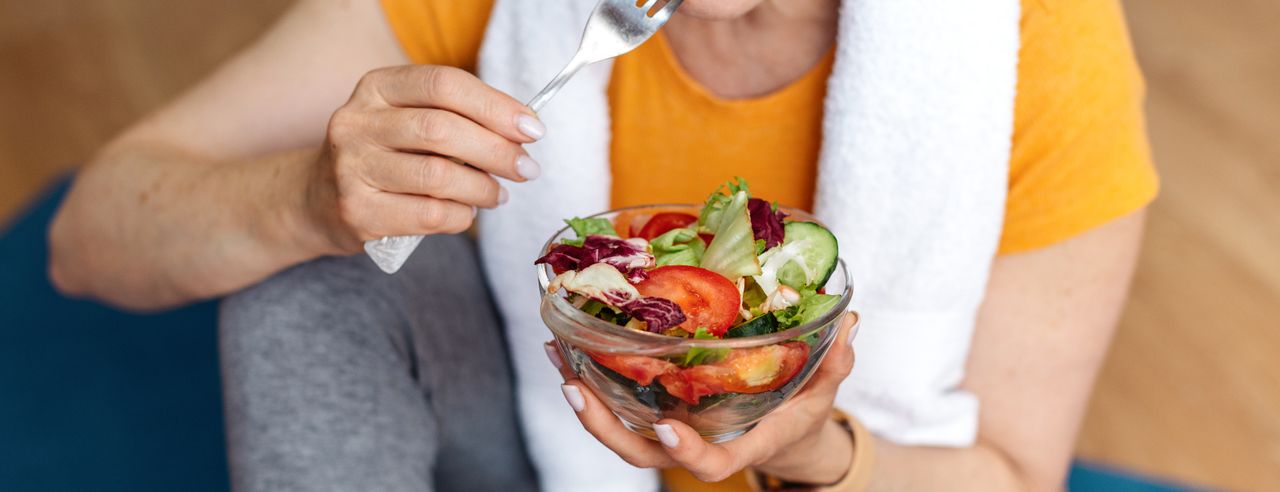 Frau auf Yogamatte mit Salat