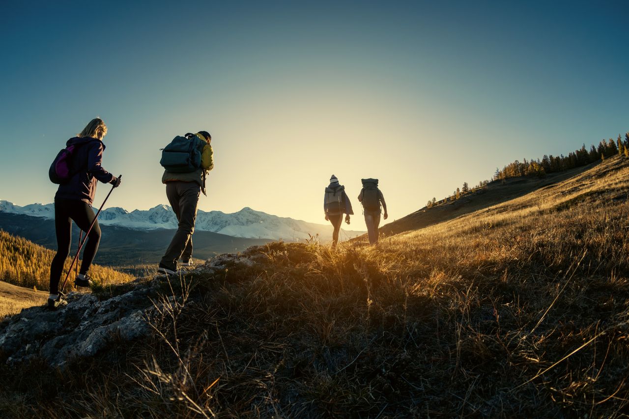 Menschen, die bei Sonnenuntergang zusammen wandern