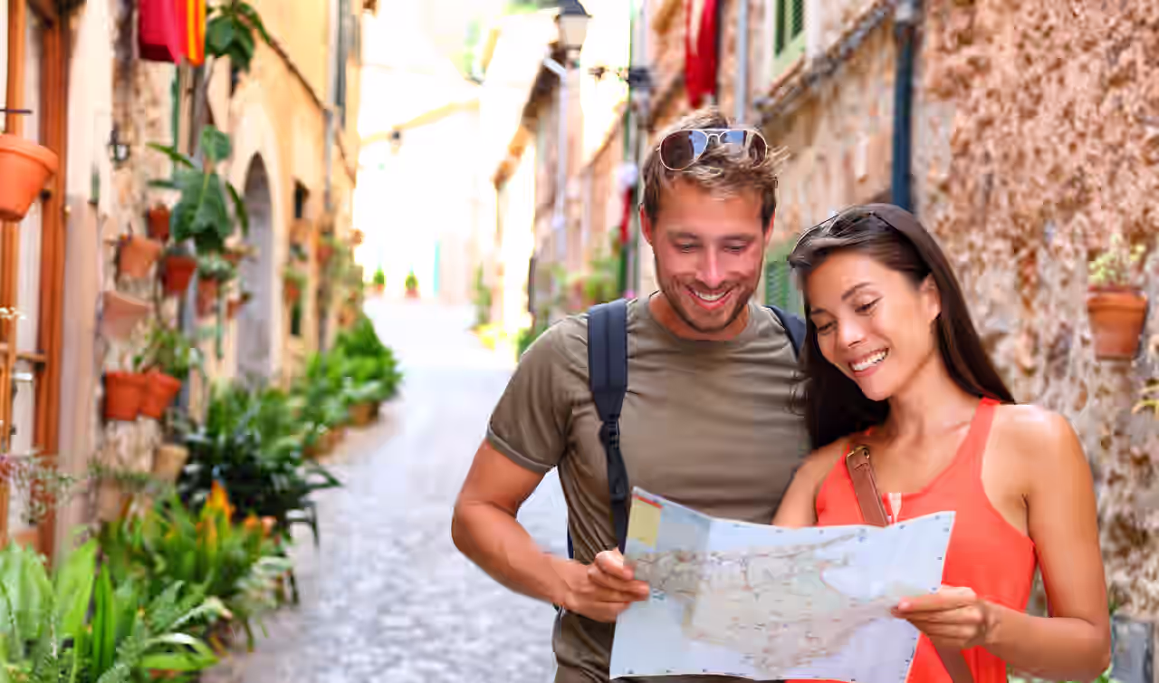 Ein Paar in einer Gasse in der Altstadt von Palme de Mallorca blickt auf eine Karte