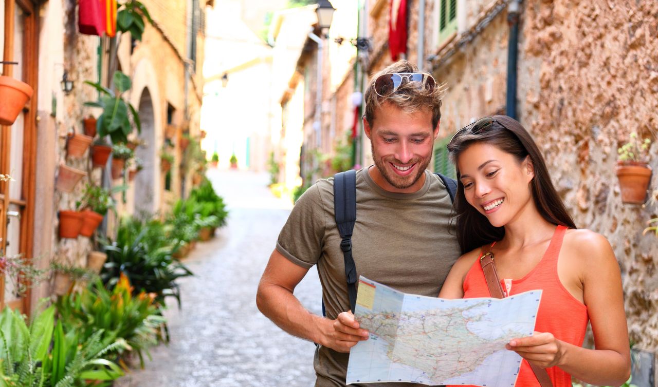 Ein Paar in einer Gasse in der Altstadt von Palme de Mallorca blickt auf eine Karte
