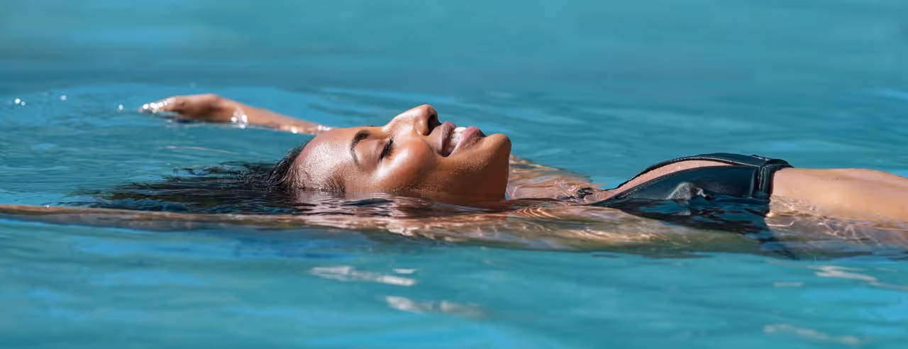 Eine Frau lässt sich im Wasser treiben beim Floating
