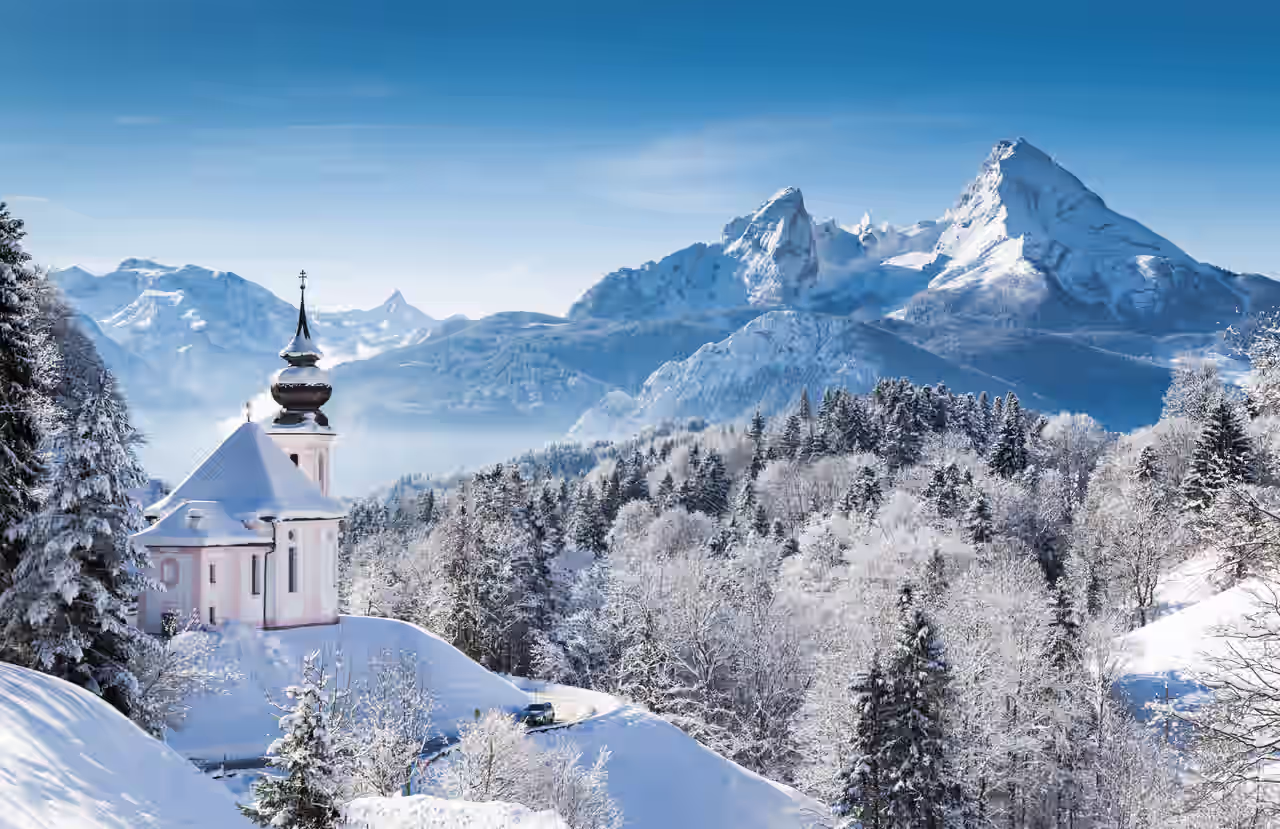 Berge, Bäume und Kirche mit Schnee bedeckt