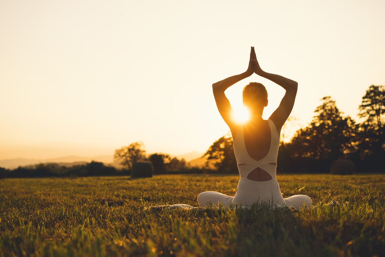 Eine Frau praktiziert in der schönen Natur von Rheinland-Pfalz Yoga in Ihrem Urlaub