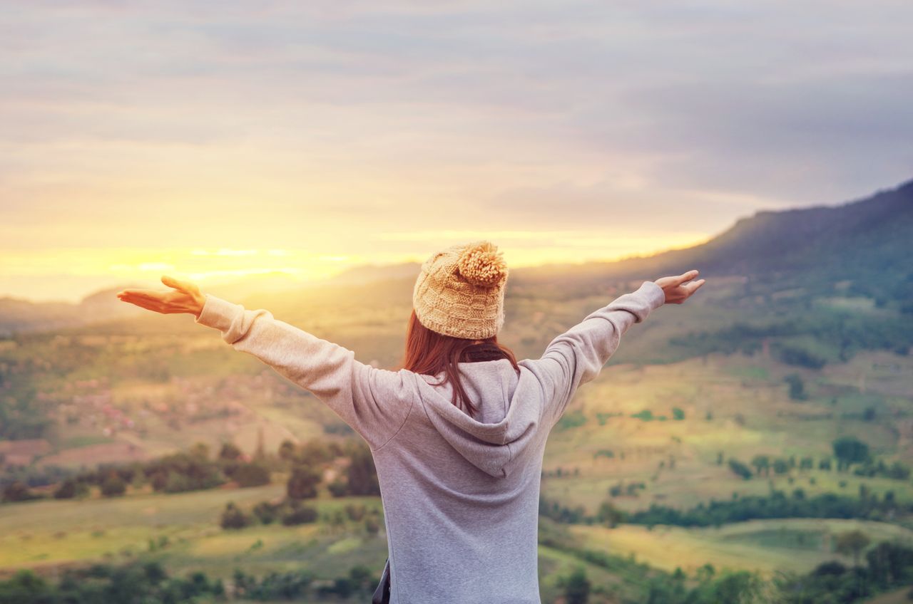 Eine Frau, die sich in einem Zustand der Freude befindet, genießt die unberührte Natur in ihrem Luftkurort.