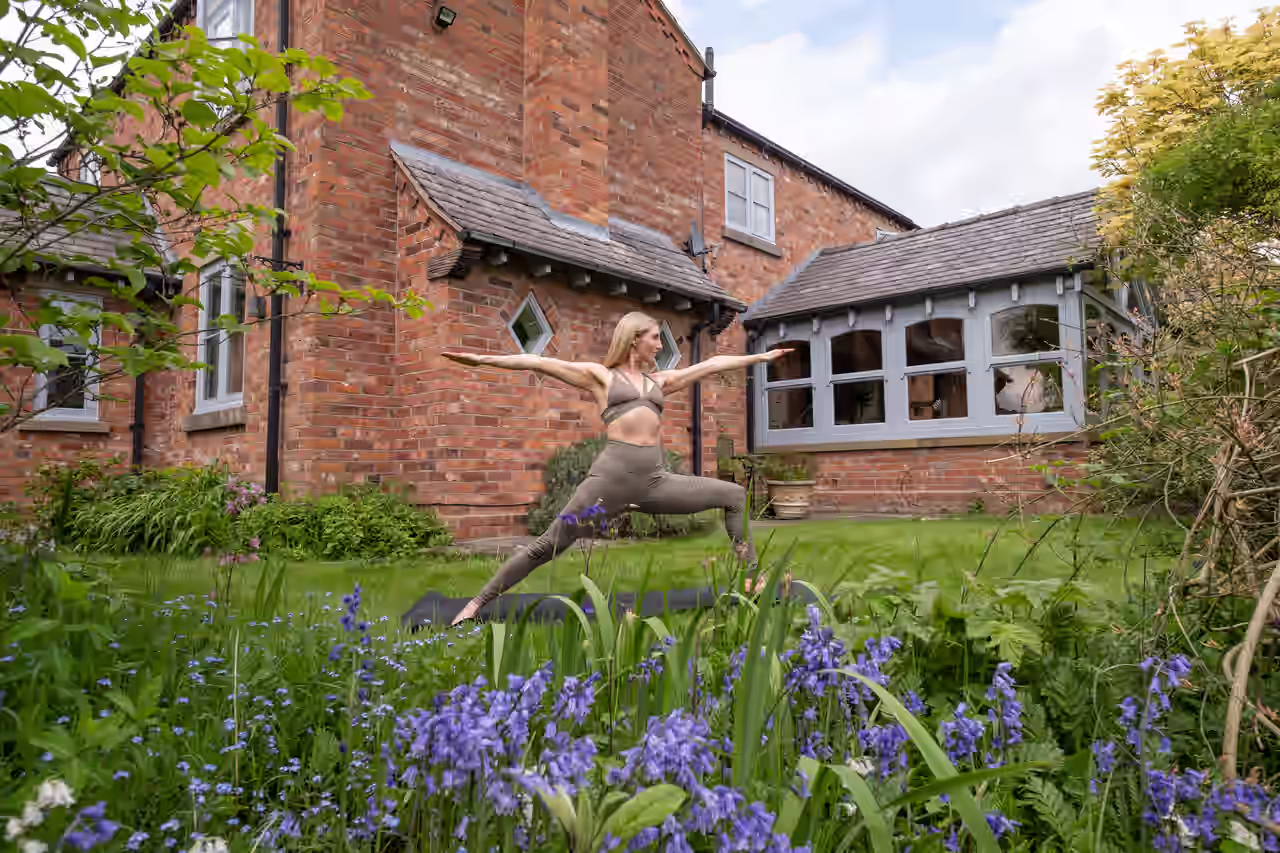 Eine Frau praktiziert Yoga in einem Garten