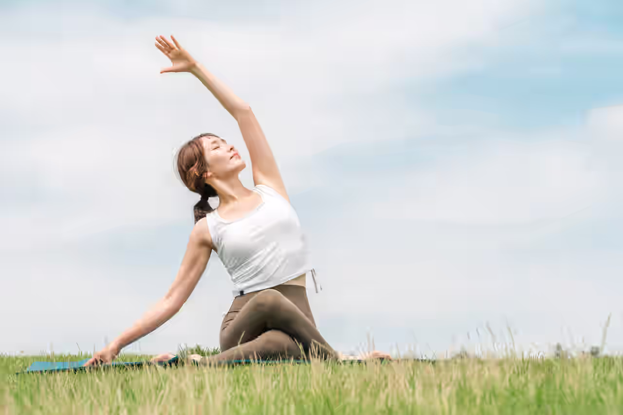 Frau beim Yoga auf einer Wiese in Deutschland