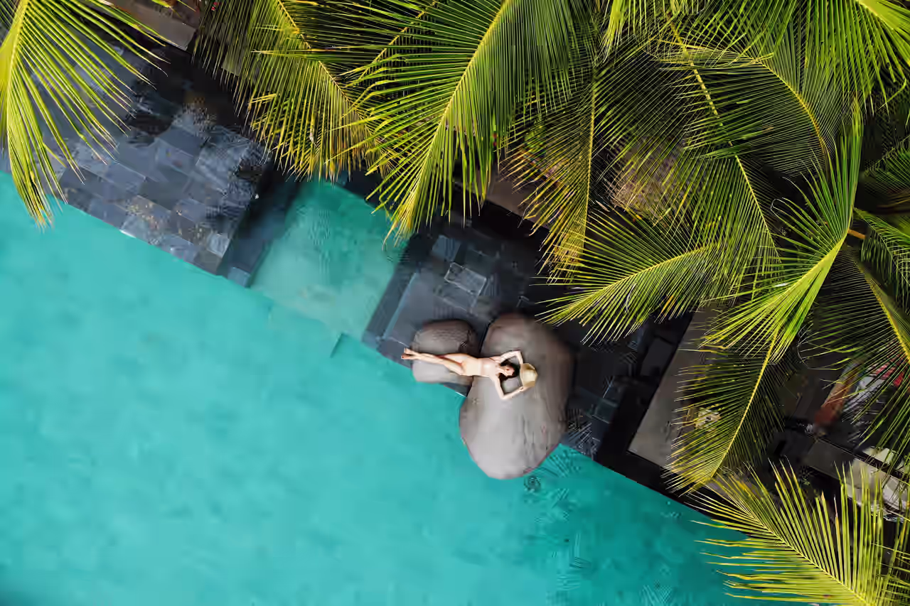 Eine glückliche Frau am Pool eines Luxushotels