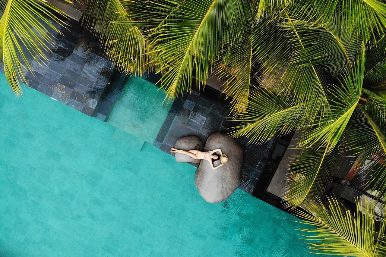 Eine glückliche Frau am Pool eines Luxushotels