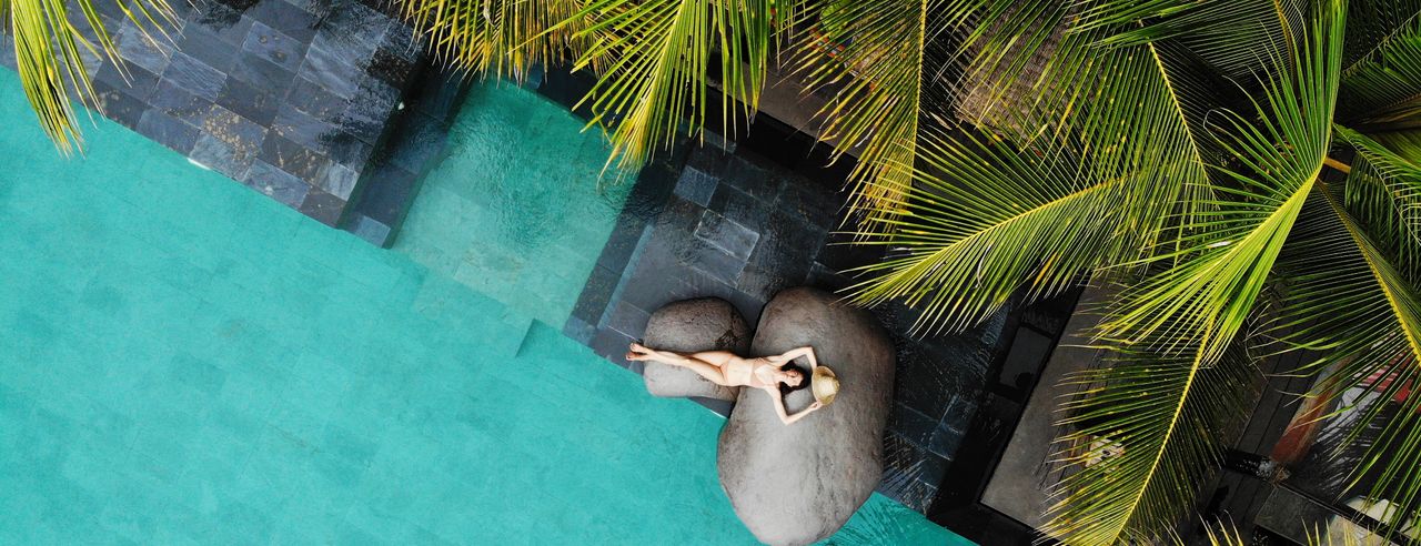 Eine glückliche Frau am Pool eines Luxushotels