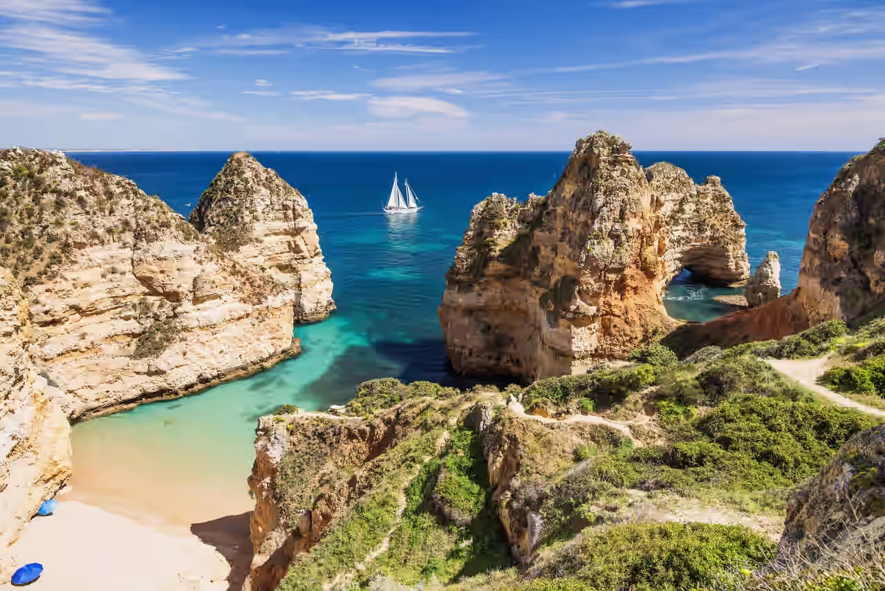 Bucht mit Segelboot in der Felsenküste an der Algarve, Portugal