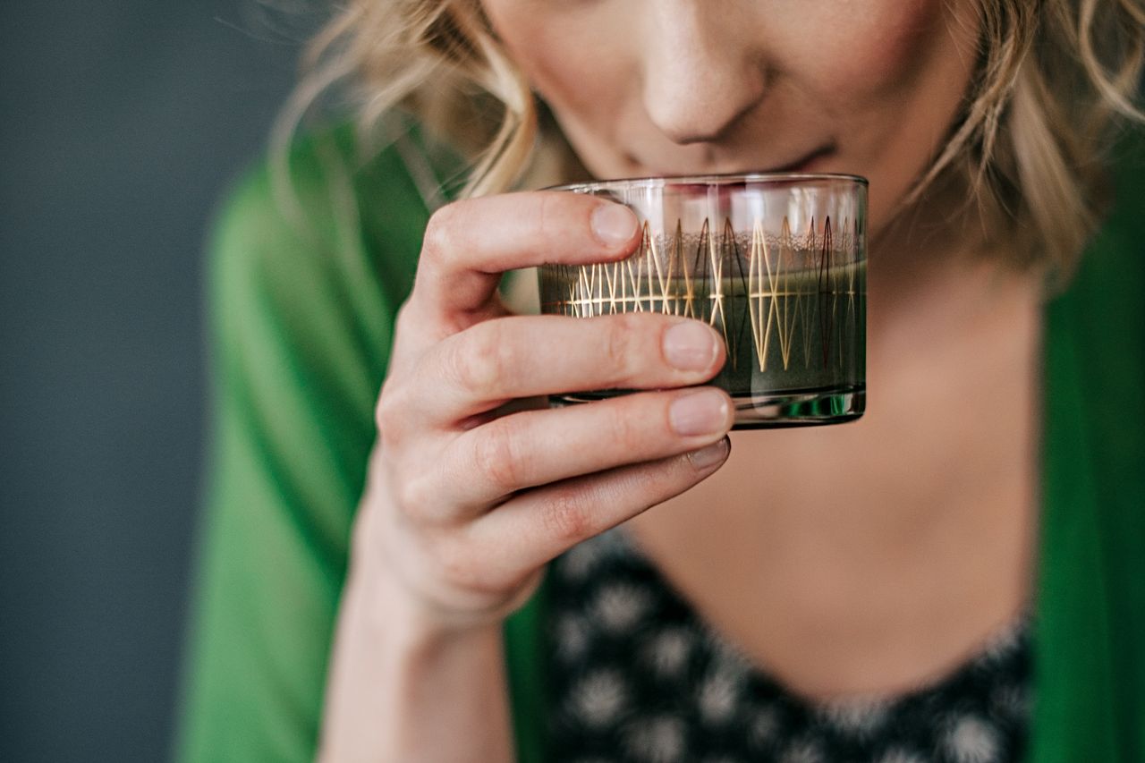 Frau hält ein Glas mit Getränk für eine Fastenkur