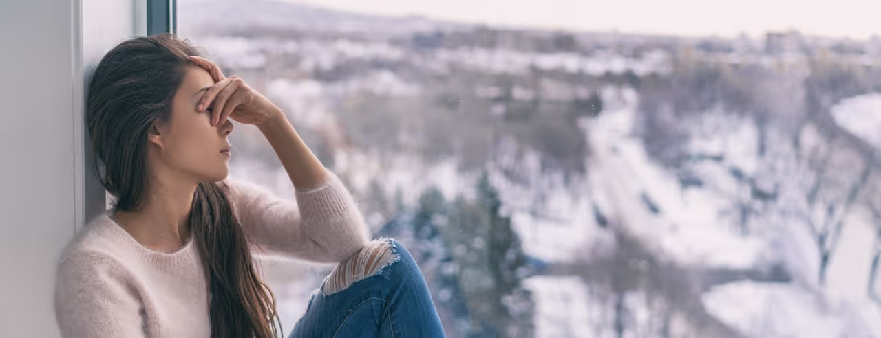 Traurige Frau am Fenster