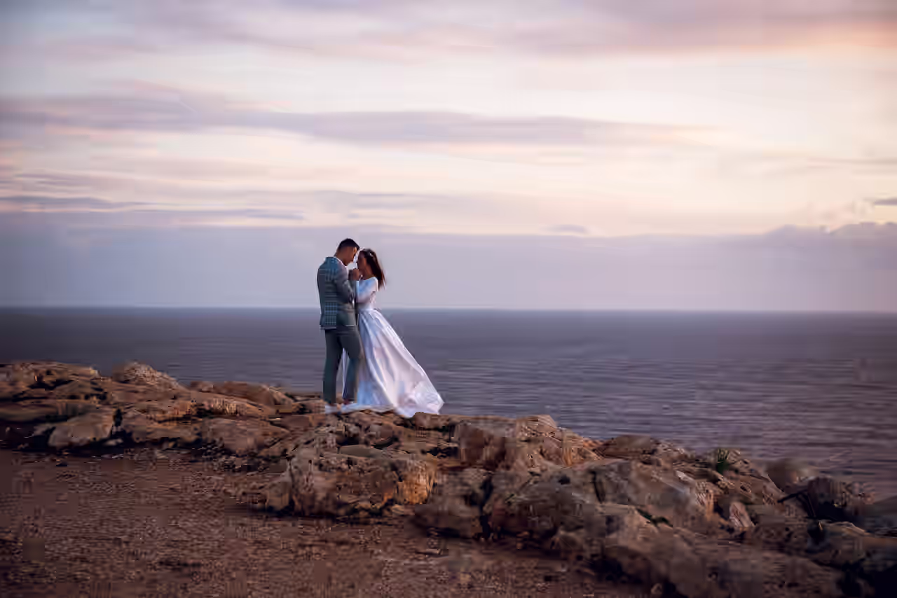 Ein Paar steht an einer Steilklippe mit Meerblick