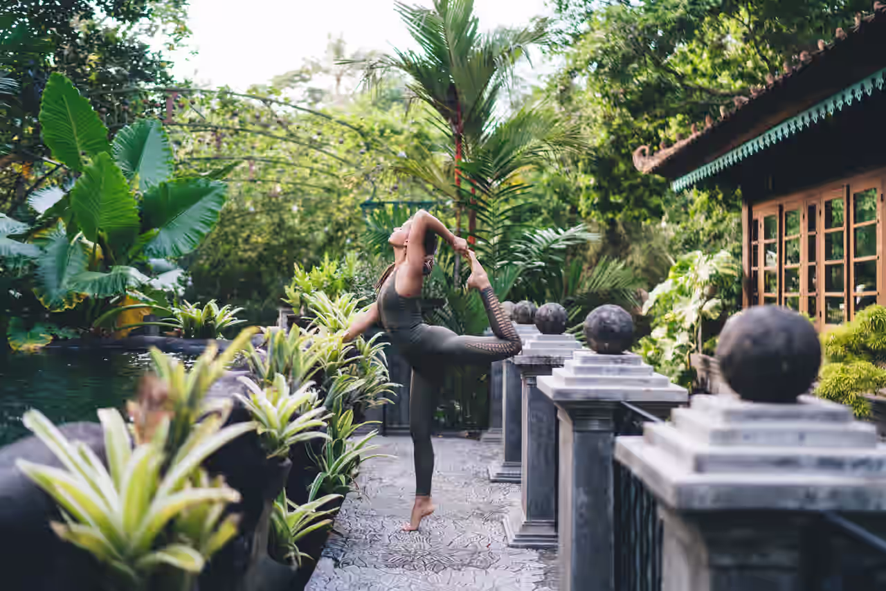 Eine Frau beim Yoga im tropischen Resort