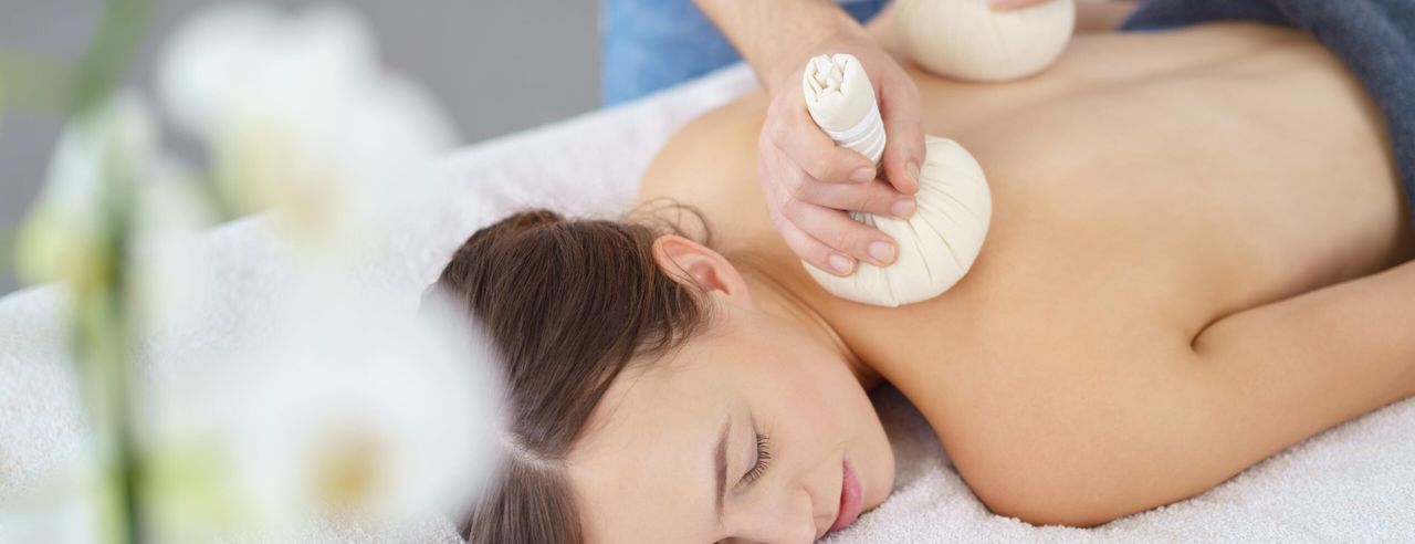 Eine Frau bei der Kräuterstempelmassage