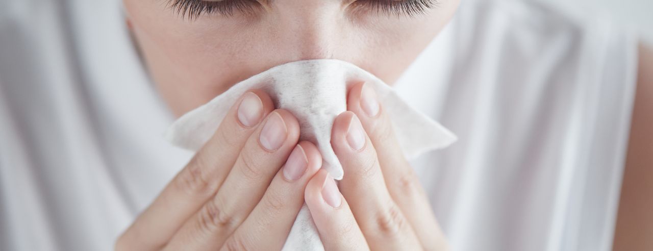 A woman blows her nose