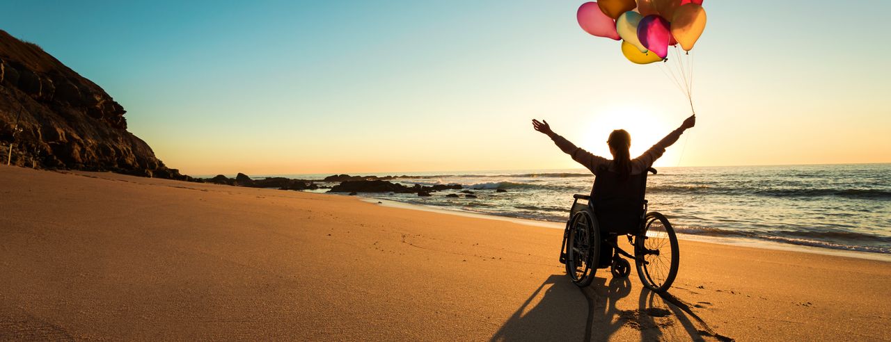 Woman in wheelchair on beach