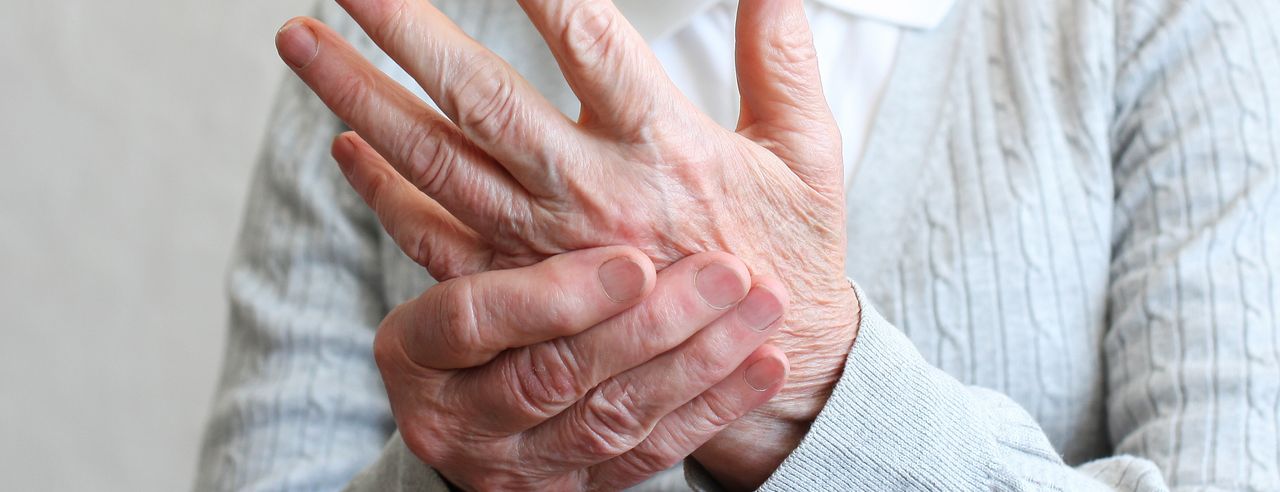 Person hält sich die schmerzende Hand